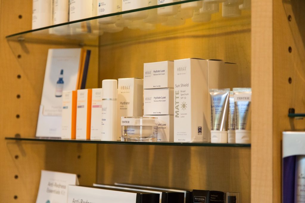A close-up view of a display showcasing various spa and skincare products at Bella Via Medical Spa, featuring beautifully arranged items with labels, creating an inviting and luxurious atmosphere for customers to explore and choose their desired products.