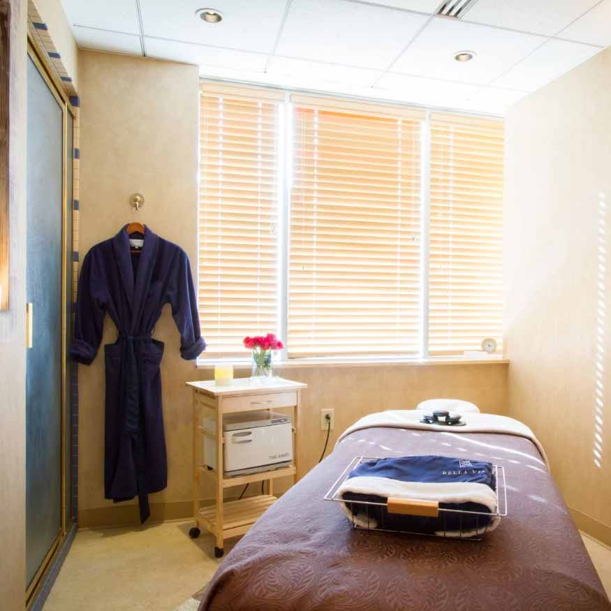 A calming spa room featuring a massage table with luxurious linens, inviting visitors to indulge in a private and rejuvenating spa experience.
