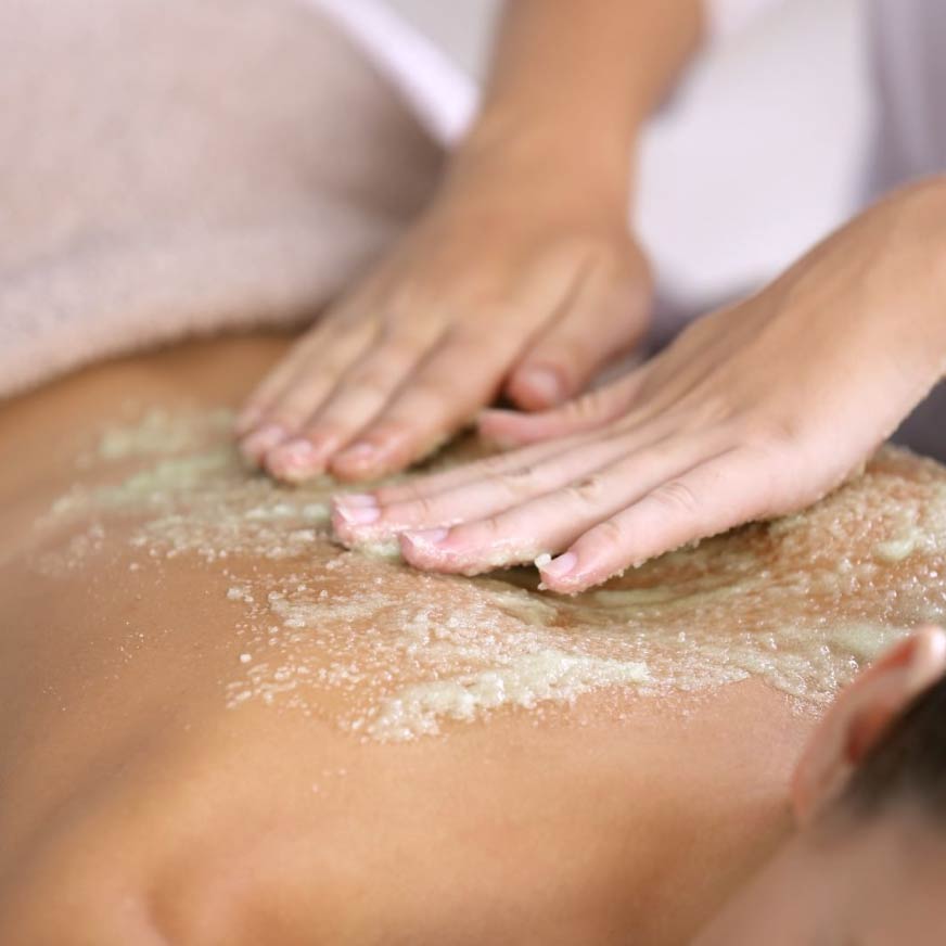 A close-up view of a person's hands providing a soothing massage on another person's back.